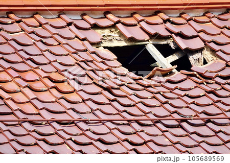 穴の空いた古い建物の石州瓦の屋根 穴の空いた古い建物の石州瓦の屋根 105689569