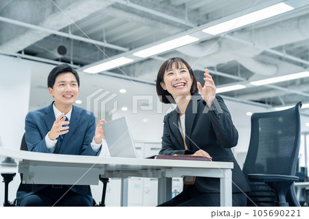オフィスで会議をする男女の若いビジネスマン オフィスで会議をする男女の若いビジネスマン 105690221