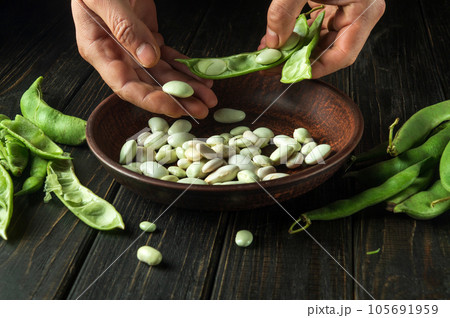 Chef cleaning green beans in the kitchen table. Close-up of cook hands while working. Organic peasant food 105691959
