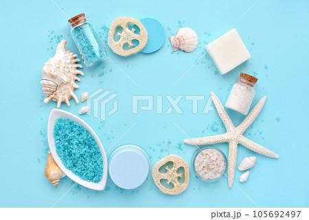Sea salt, cream, lotion, soap, sponges and shells in cosmetics set for spa on blue background. Sea salt, cream, lotion, soap, sponges and shells in cosmetics set for spa on blue background. 105692497