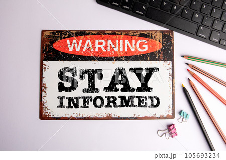 Stay Informed Concept. Warning sign on a white office desk Stay Informed Concept. Warning sign on a white office desk 105693234