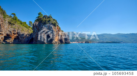 Picturesque view on rocks on a sunny day from the sea. Budva riviera, Montenegro Picturesque view on rocks on a sunny day from the sea. Budva riviera, Montenegro 105693458