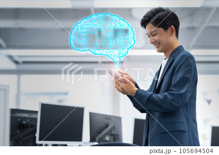 オフィスでスマホを操作して働くの若い男性のエンジニア オフィスでスマホを操作して働くの若い男性のエンジニア 105694504