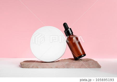 Amber glass dropper cosmetic bottles, white podium. Natural skin care SPA beauty product design. Mineral organic oil on pink background. Mock-Up. Oily pipette. Face and body treatment. Front view Amber glass dropper cosmetic bottles, white podium. Natural skin care SPA beauty product design. Mineral organic oil on pink background. Mock-Up. Oily pipette. Face and body treatment. Front view 105695193