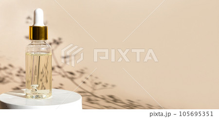 Natural oil cosmetics on neutral background. Dropper glass Bottle Mock-Up. Oily cosmetic pipette. Face and body treatment. Spa concept. Mineral organic oil. Flat lay with beauty products. Blank bottle Natural oil cosmetics on neutral background. Dropper glass Bottle Mock-Up. Oily cosmetic pipette. Face and body treatment. Spa concept. Mineral organic oil. Flat lay with beauty products. Blank bottle 105695351