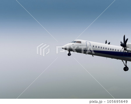 薄曇りの空を飛行する旅客機 105695649