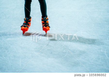 Close-up of a girl's legs in w fashion skates on an outdoor ice rink, a young girl skating thinking on the open rink 105696002