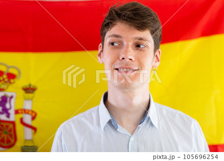 Portrait of positive student against background of flag of Spain Portrait of positive student against background of flag of Spain 105696254