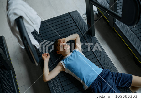 Tired exhausted boy rest lying on treadmill after hard practice 105696393