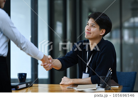 Smiling young businessman shaking hands closing deal or making agreement after successful negotiations Smiling young businessman shaking hands closing deal or making agreement after successful negotiations 105696546