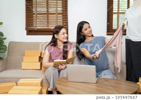 Startup small business owner working with computer at workplace. Freelance two woman seller check product order. Packing goods for delivery to customer. Online selling. E-commerce. Shipping concept 105697687