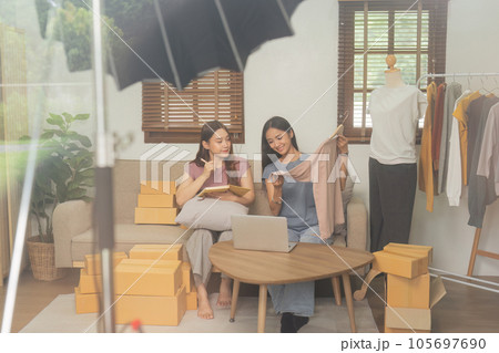 Startup small business owner working with computer at workplace. Freelance two woman seller check product order. Online selling. E-commerce. Behind the scene concept 105697690