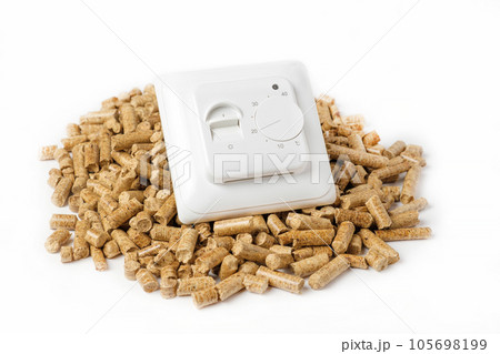 Wooden Pellets with Thermostat. Thermostatic Valve Head Isolated on White Background. Renewable Source of Heating. Biofuel. Ecologic Fuel made from Biomass. The Alternative Energy Source. Gas Crisis. 105698199