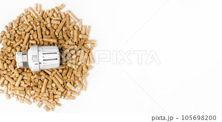 Wooden Pellets with Thermostat. Thermostatic Valve Head Isolated on White Background. Renewable Source of Heating. Biofuel. Ecologic Fuel made from Biomass. The Alternative Energy Source. Gas Crisis. 105698200