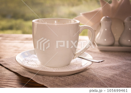 Cup of coffee with a saucer on the table in the cafe. Cup of coffee with a saucer on the table in the cafe. 105699461