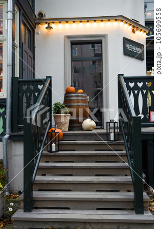 Decorative vintage wooden door with colorful plants in pots. 105699558