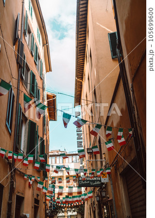 Holiday in the Italian city of streets with Italian flags and ancient buildings.Pisa, Italy. 105699600