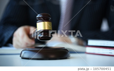 Judge holding hammer in hand lies 105700451