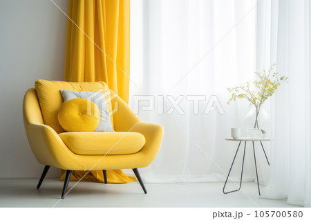 A yellow armchair stands near the window in the interior 105700580