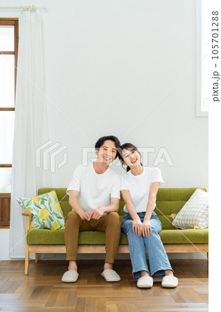 リビングでくつろぐ若い夫婦 リビングでくつろぐ若い夫婦 105701288