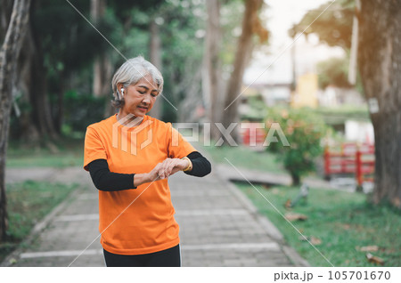 white-haired elderly person exercising in the park early in the morning. 105701670