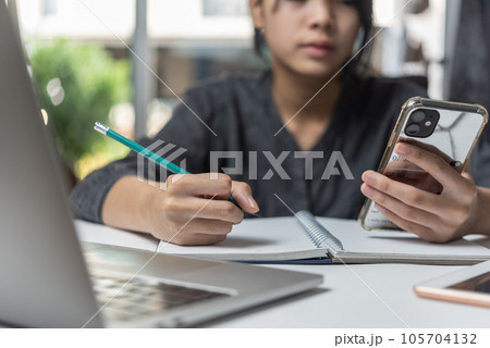 Woman hands with pen writing on notebook in the office.learning, education and work.writes goals, plans, make to do and wish list on desk. Woman hands with pen writing on notebook in the office.learning, education and work.writes goals, plans, make to do and wish list on desk. 105704132
