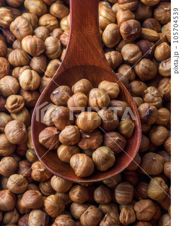 Peeled hazelnuts in close-up with wooden spoon. View from above. Promotional photo of healthy nut Peeled hazelnuts in close-up with wooden spoon. View from above. Promotional photo of healthy nut 105704539
