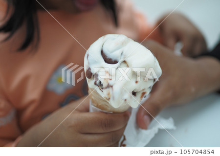 Child Hand Holding Vanilla Ice Cream in A Waffle Cone. Child Hand Holding Vanilla Ice Cream in A Waffle Cone. 105704854