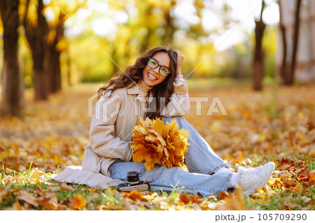 Beautiful woman taking pictures in autumn forest. Woman enjoying autumn weather. Lifestyle concept. Beautiful woman taking pictures in autumn forest. Woman enjoying autumn weather. Lifestyle concept. 105709290