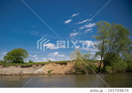 beautiful landscape on the river bank with blue sky and tree beautiful landscape on the river bank with blue sky and tree 105709674