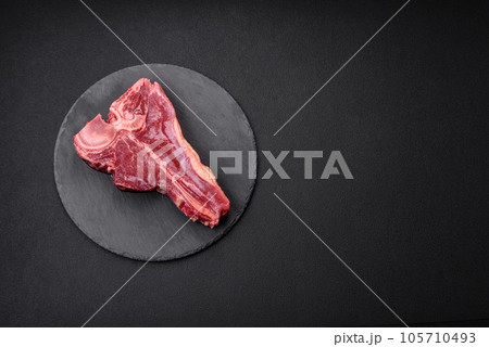 Raw fresh juicy beef t-bone steak with salt, spices and herbs Raw fresh juicy beef t-bone steak with salt, spices and herbs 105710493