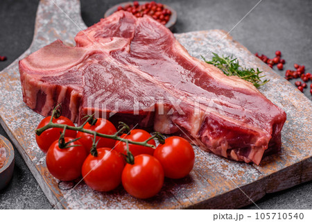 Raw fresh juicy beef t-bone steak with salt, spices and herbs 105710540