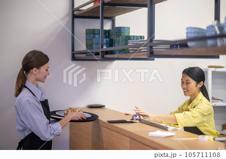 Waitress taking the order from the counter at the cafe Waitress taking the order from the counter at the cafe 105711108