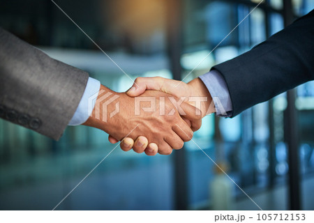 A handshake showing teamwork, collaboration and togetherness by business colleagues after a meeting in the office. A successful agreement has been reached by male coworkers in a business deal 105712153