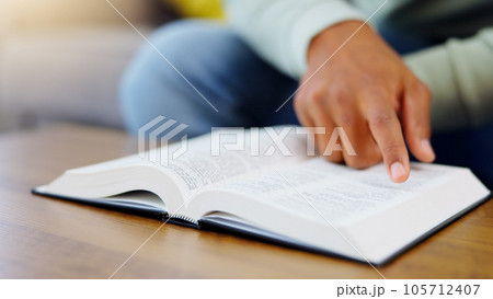 Prayer, reading and bible with man in living room for worship, spiritual and Christian faith. Hope, God and belief with person praying with holy book at home for religion, thinking and gratitude 105712407
