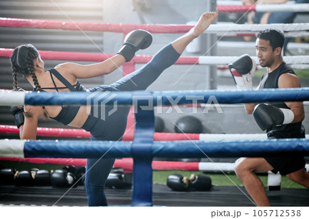 Fit, active and healthy boxing team kicking or fighting in workout, ring training or exercise in a wellness center. Sporty, athletic or strong man and woman kickboxing in combat fight or sports match Fit, active and healthy boxing team kicking or fighting in workout, ring training or exercise in a wellness center. Sporty, athletic or strong man and woman kickboxing in combat fight or sports match 105712538