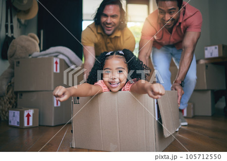 Family home, girl and box with father, push and gay parents with games, portrait and excited on floor with moving. LGBTQ men, female kid and cardboard package for car, airplane and speed in new house 105712550