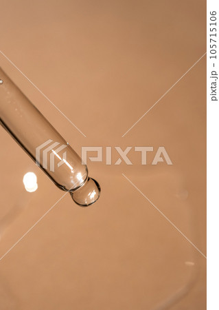 A pipette of cosmetic gel on a beige background. A pipette of cosmetic gel on a beige background. 105715106