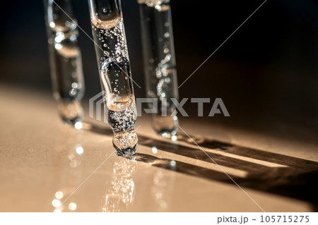 Three pipettes of cosmetic gel on a beige background. Three pipettes of cosmetic gel on a beige background. 105715275