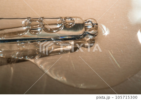 A pipette of cosmetic gel on a beige background. 105715300