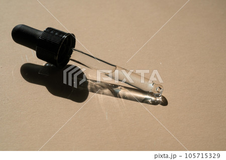 A pipette of cosmetic gel on a beige background. A pipette of cosmetic gel on a beige background. 105715329