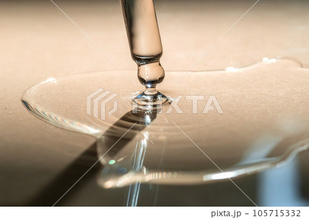 A pipette of cosmetic gel on a beige background. 105715332