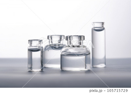 Different bottles of water on a light background. It can fit the theme of cosmetics, glass and freshness. Different bottles of water on a light background. It can fit the theme of cosmetics, glass and freshness. 105715729