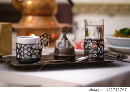 Water, espresso and a sugar container on a Turkish-style tray. 105715767
