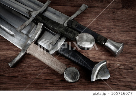 Medieval swords on wooden backgrond. Medieval swords on wooden backgrond. 105716077