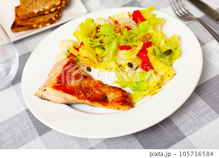 Grilled salmon steak with fresh lettuce salad 105716584