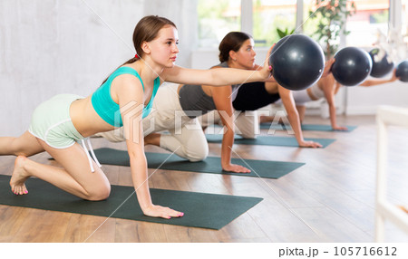 Girl participates in group lesson with sof tball, modern sport in studio. 105716612