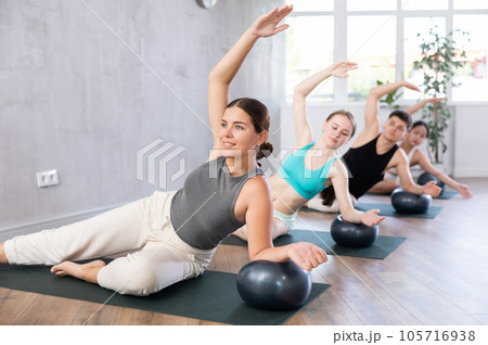 Girl coach leads, conducts group lesson with softball, modern sports in studio. Girl coach leads, conducts group lesson with softball, modern sports in studio. 105716938