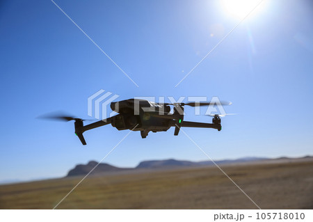 Flying drone in high altitude mountains 105718010