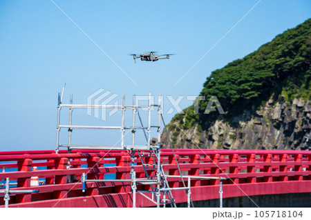 橋梁点検のためドローンを操縦する男性作業員｜ドローン点検イメージ 105718104